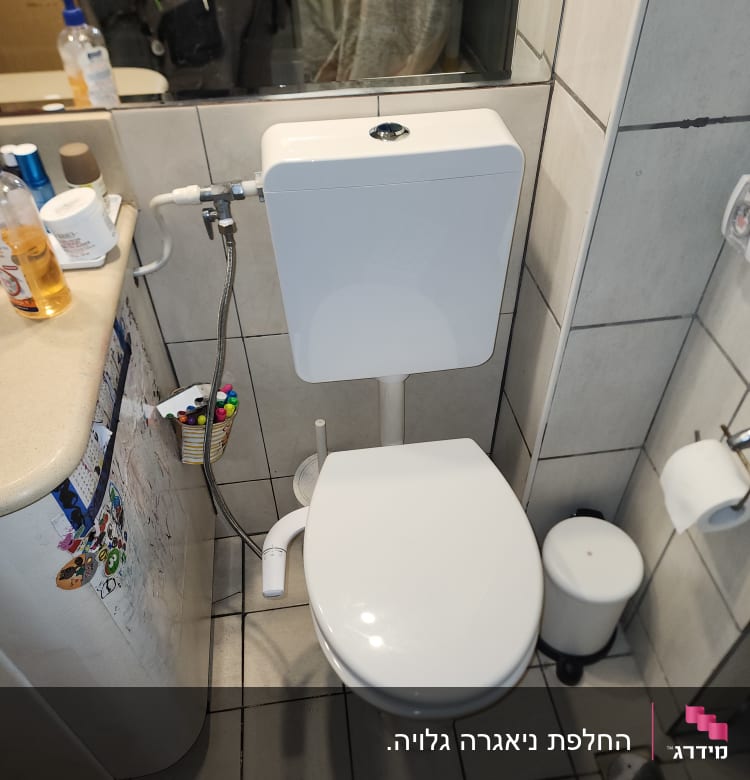 אסלה עם מיכל הדחה וכלי עבודה של אינסטלטור